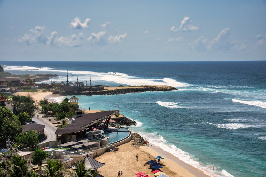 Travelers enjoying Bali beaches with breathtaking sunsets, tropical landscapes, surfing opportunities, and a variety of beach experiences across the island.