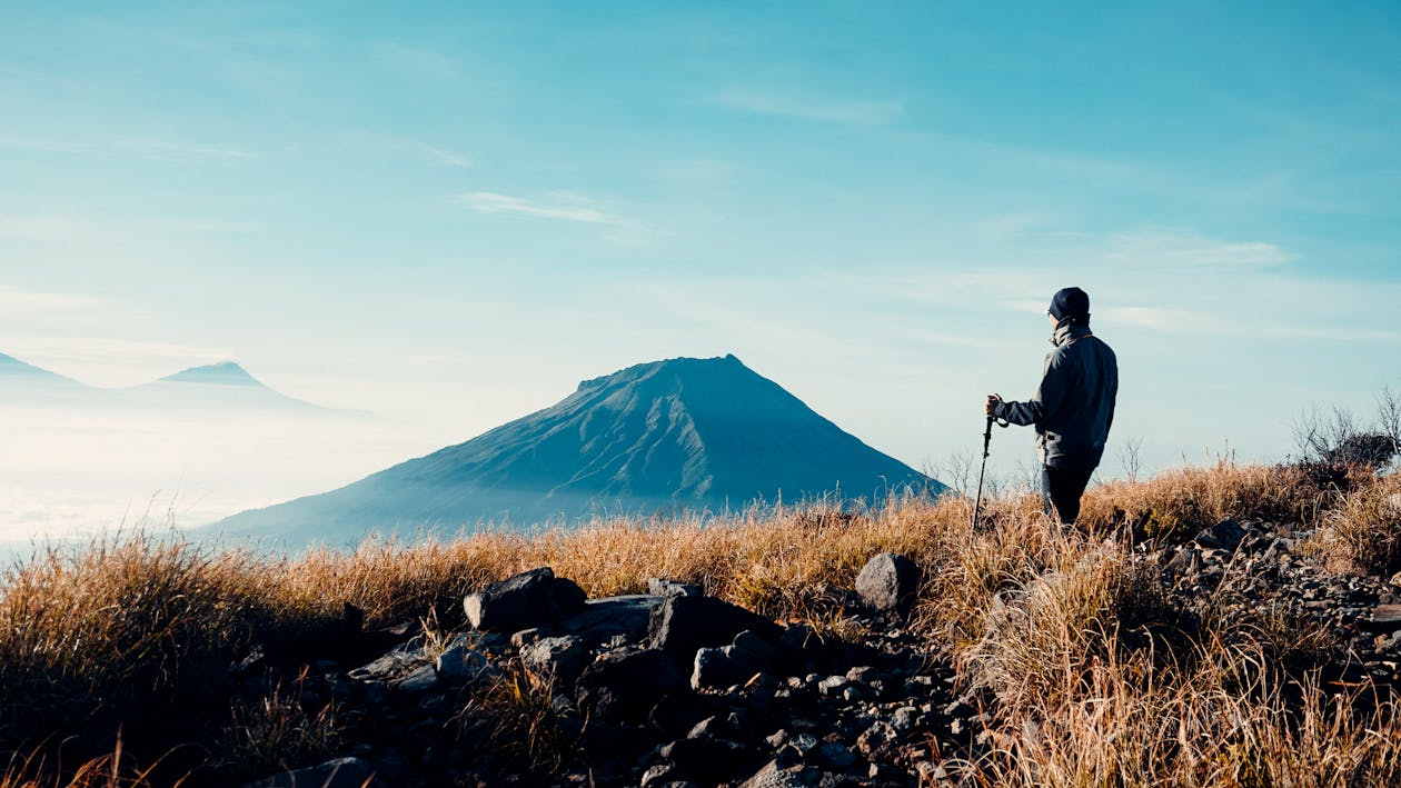 Travelers exploring a Bali volcano through guided treks, sunrise hikes, and panoramic lookouts overlooking lush valleys, lakes, and surrounding countryside.