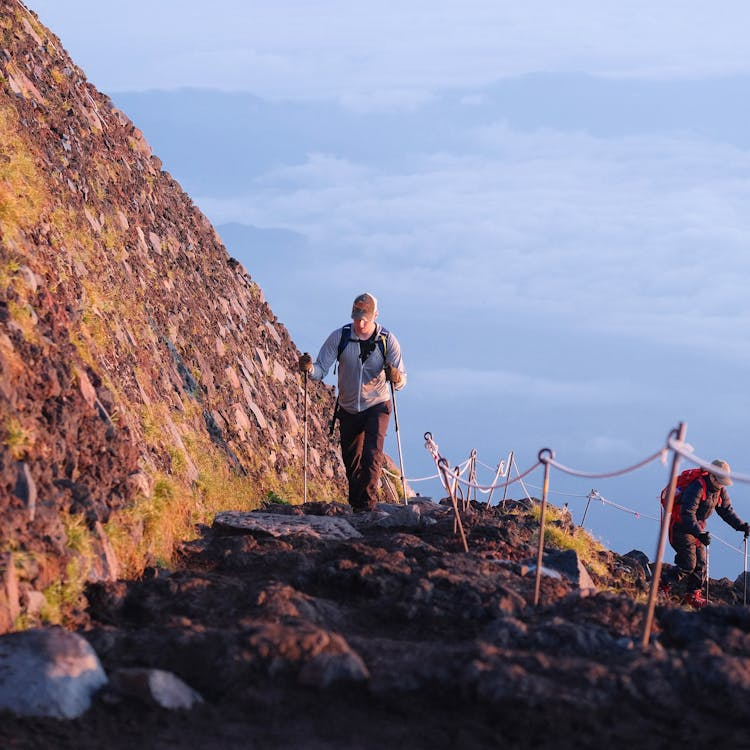 Travelers exploring a Bali volcano through guided treks, sunrise hikes, and panoramic lookouts overlooking lush valleys, lakes, and surrounding countryside.