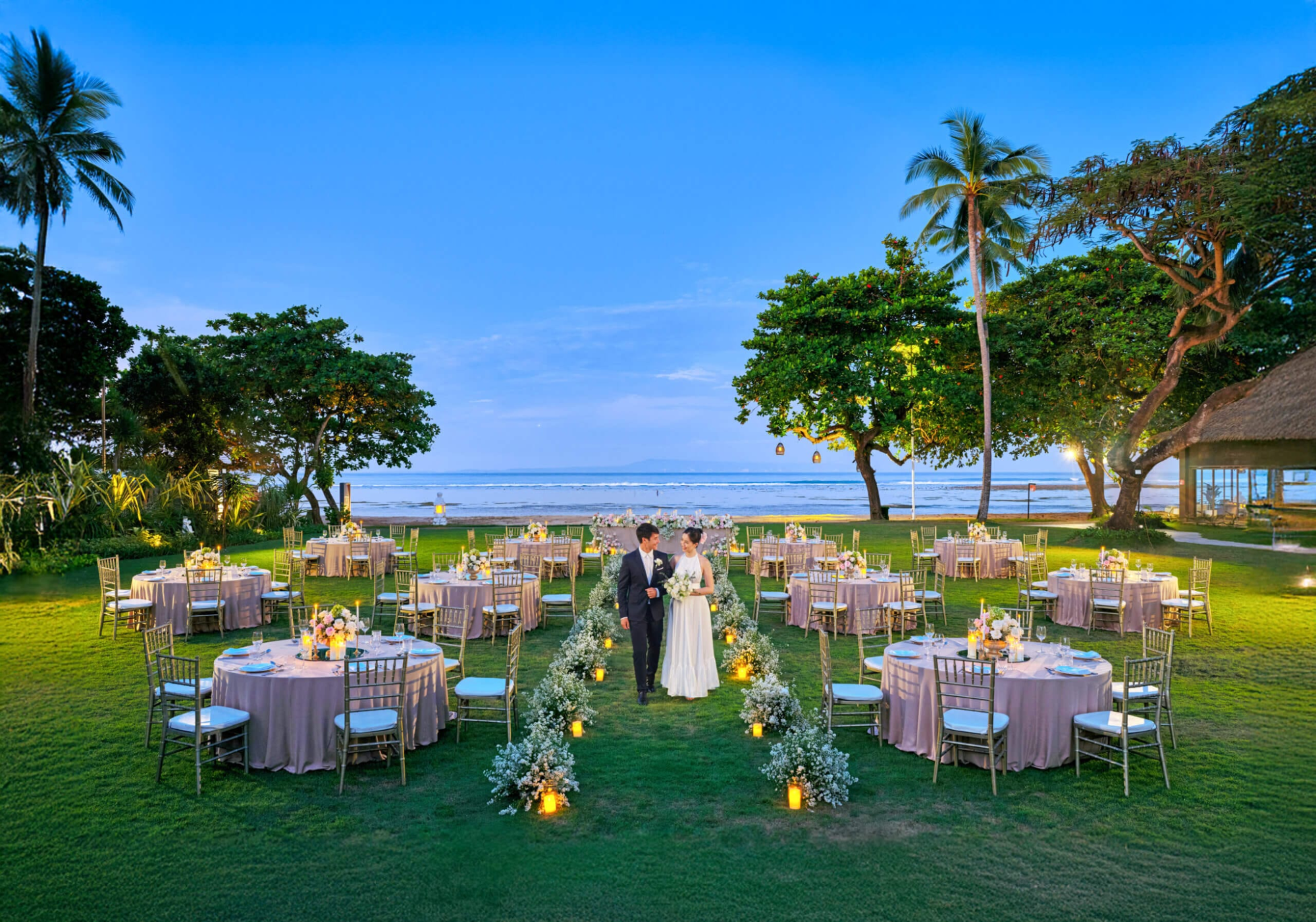 Couple celebrating a luxury wedding in Sanur, Bali at a five-star resort with personalized wedding services, tropical gardens, and a stunning seaside setting.